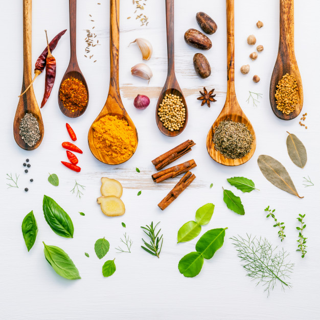 various-herbs-spices-wooden-spoons-wooden-background_35641-561